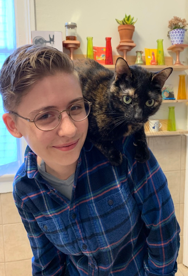 Heather smiling with cat on her shoulders